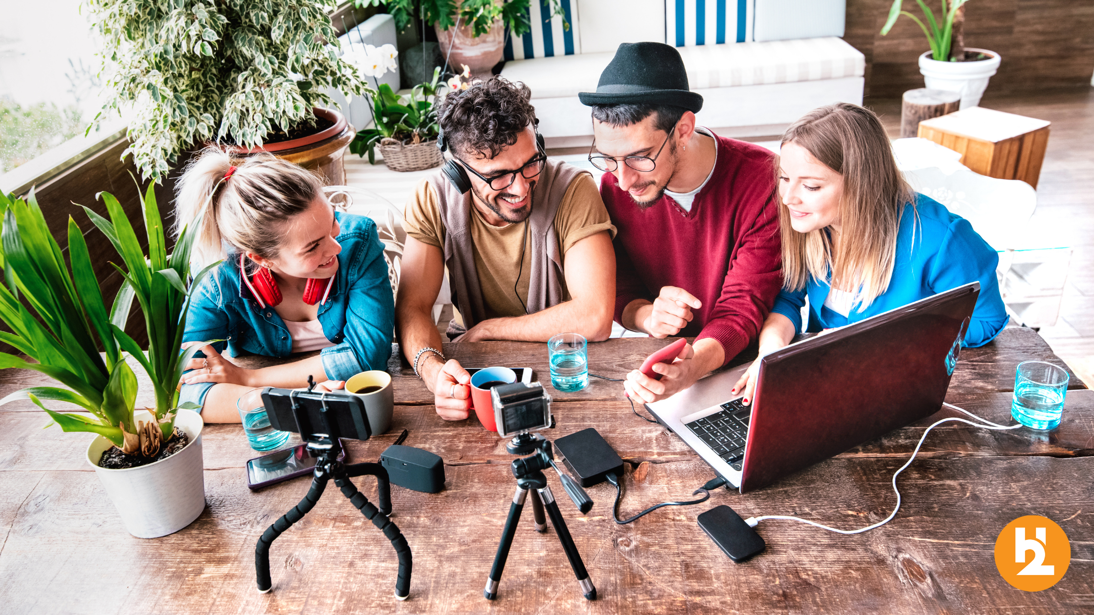 Content creators creating UGC at their table with cameras and laptops.