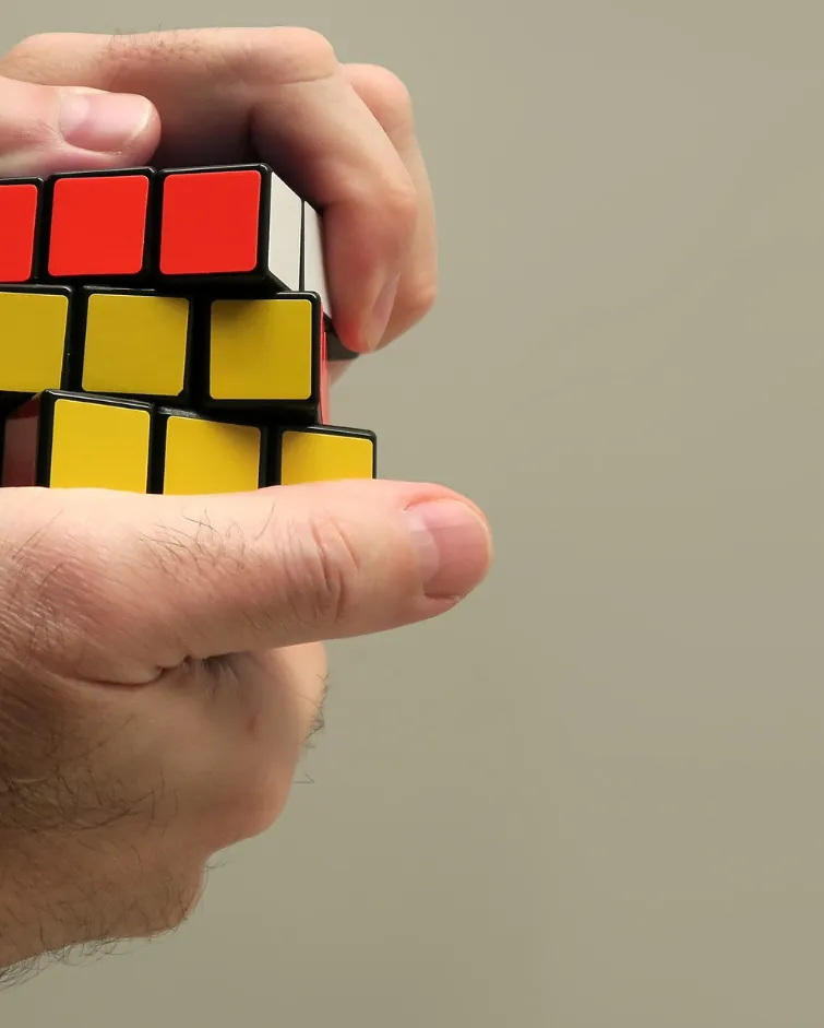 Two hands playing with a Rubrik cube