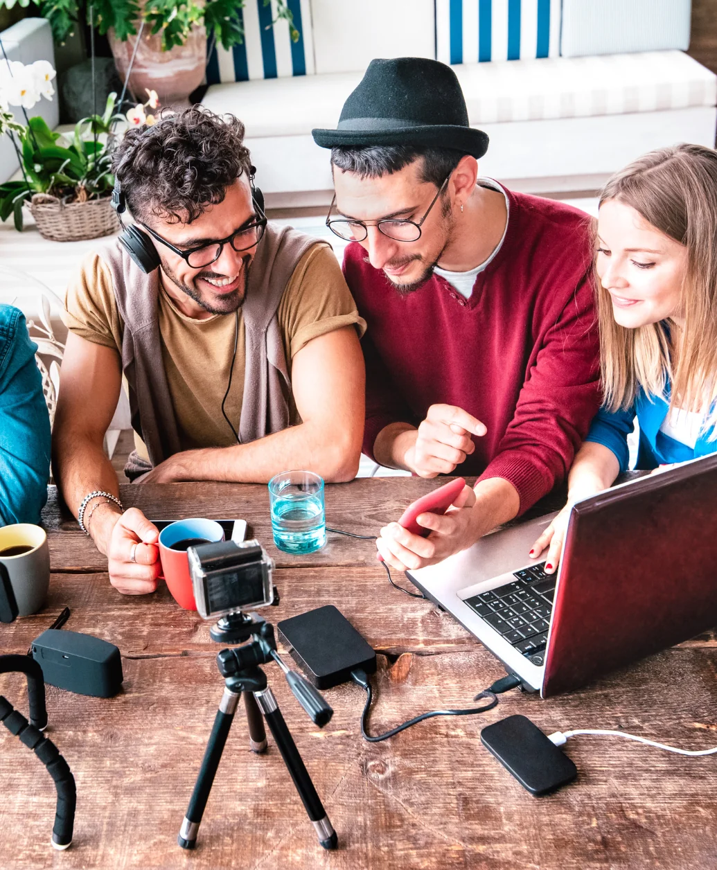 Content creators creating UGC at their table with cameras and laptops.